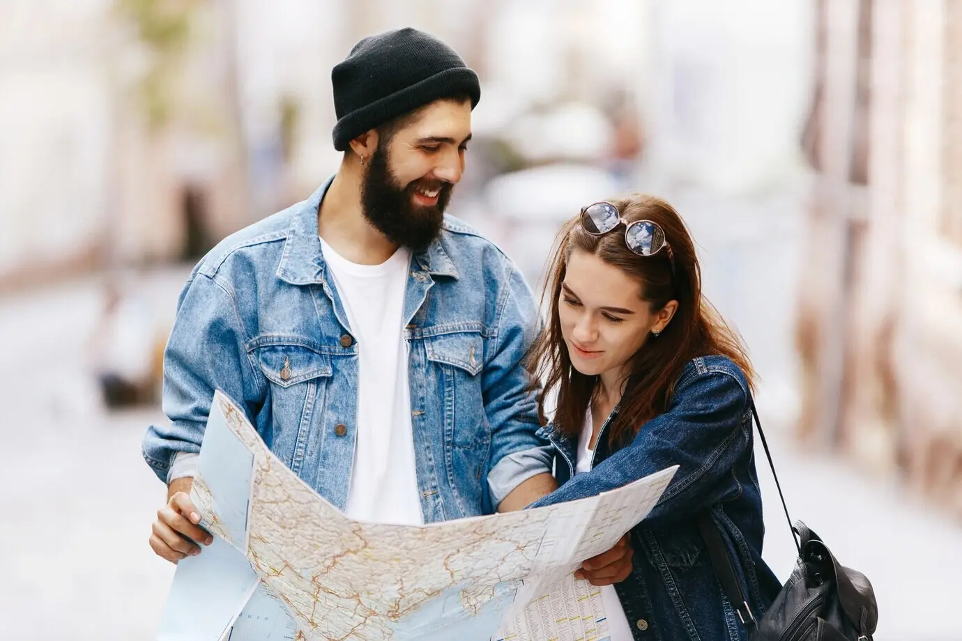 A man and a woman are standing somewhere in an old city, looking at a map.