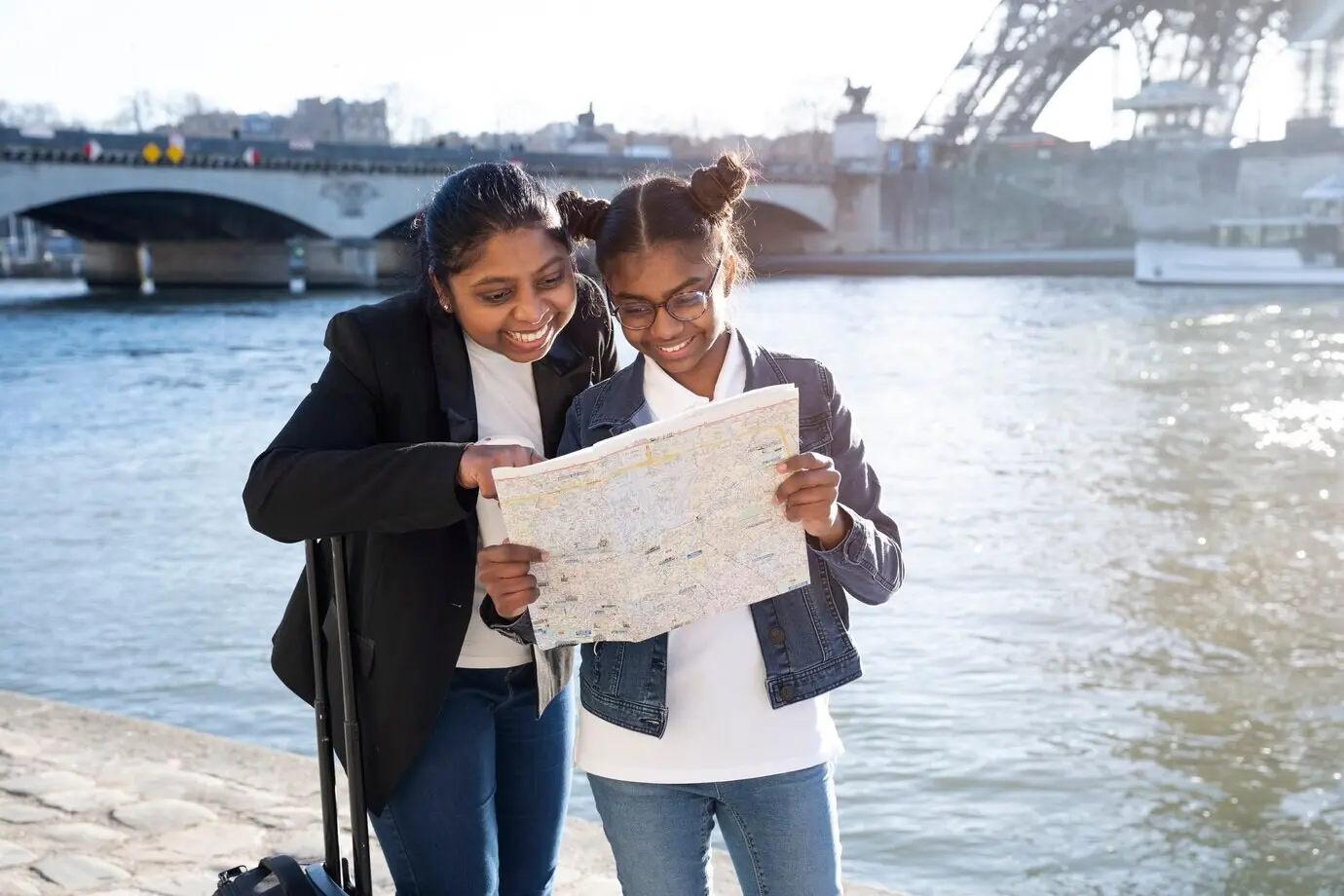 An African American mother and daughter looking at a map on her trip to Paris