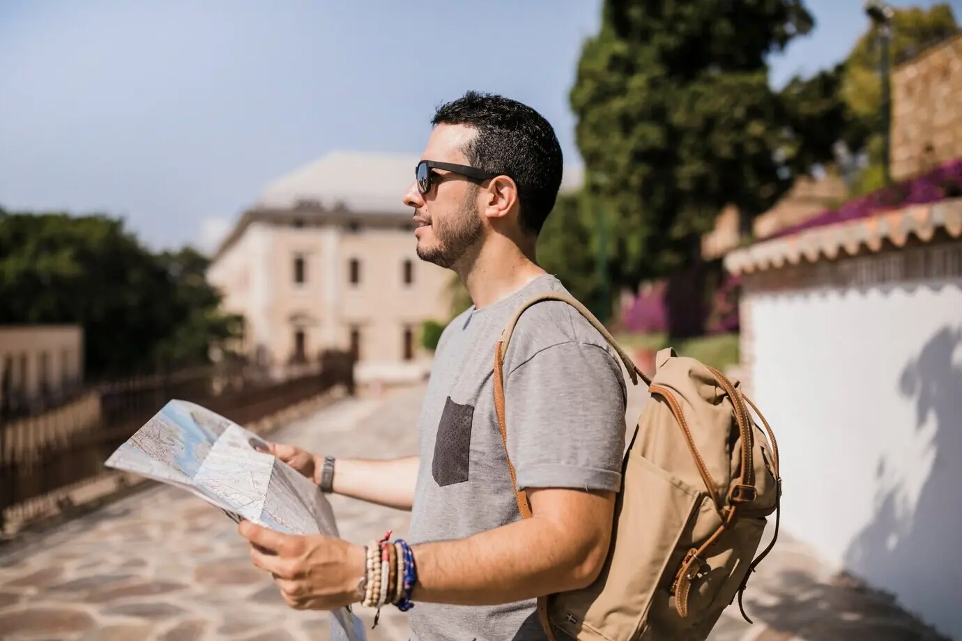 A close-up view of a male tourist holding a map in his hand.
