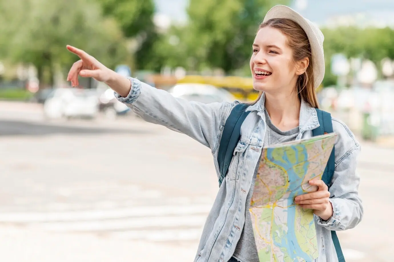 Front view of a woman holding a map and pointing her finger in the air.